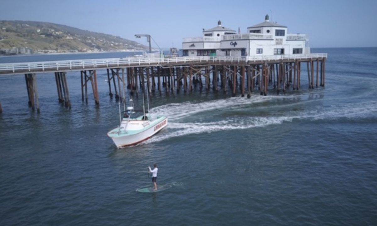 Paddle board surfer being stopped by Malibu lifeguards for ignoring the LA County beach closure mandate. | Photo courtesy: Lost Hills Sheriff's Station Facebook