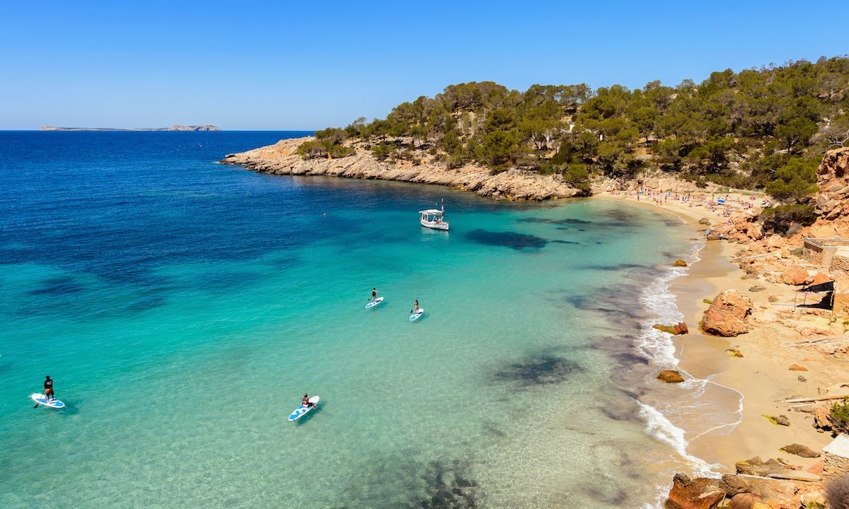 Ibiza, Cala Saladeta. One of the best beaches on the west side of the island. Crystal clear waters, white sands and the shade of pine trees. | Photo: Shutterstock