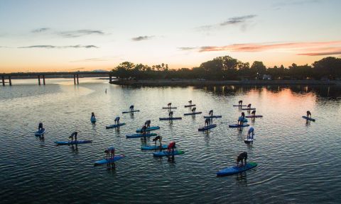 Starboard employees, team members an friends all take part in an evening SUP Yoga session on Mission Bay. | Photo: Georgia Schofield